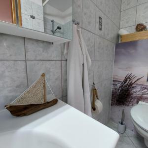a bathroom with a white sink and a toilet at "NordWest" Ferienwohnung in Prerow +17 photos