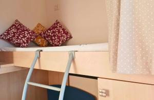 a bunk bed with pillows and a desk with a chair at La Perla Marina - Furnari in Torre Forte +1 photo
