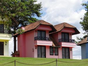 a pink house with black windows at Fazenda do Engenho Parque Hotel in Piratuba