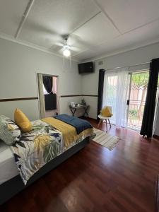 a bedroom with a bed and a wooden floor at Tanya's Haven Guesthouse in Klerksdorp