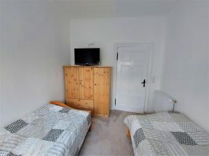 a bedroom with two beds and a tv on a cabinet at Komfortfewo Meeresleuchten in Sassnitz