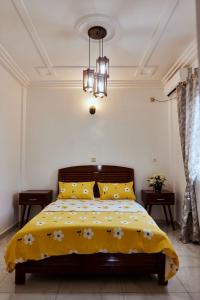 a bedroom with a bed with a yellow blanket at MH - Upper Floor Apart in Douala