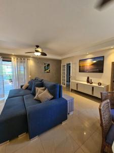 a living room with a blue couch and a tv at bwelcome - aconchego pé na areia mod 2 in Bertioga