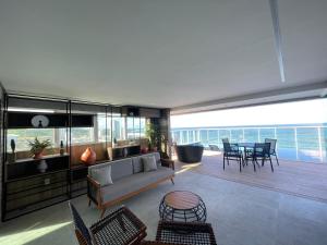 a living room with a couch and a table and chairs at RN Studio Premium Max Rev in Maceió