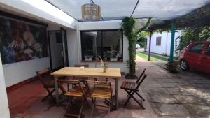 a wooden table and chairs on a patio at Gen Viajero Hostel in Merlo