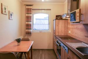 メッペンにあるFamilienhof Brüning - Ferienwohnung Hofblickの小さなキッチン(木製テーブル、小さなダイニングテーブル付)
