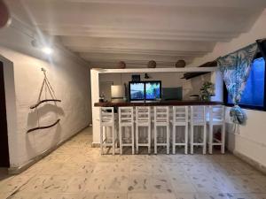 a living room with a bar with white stools at Casa Holboxeños in Holbox Island