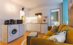 a living room with a couch and a kitchen at Le Flocon Doré in Cauterets