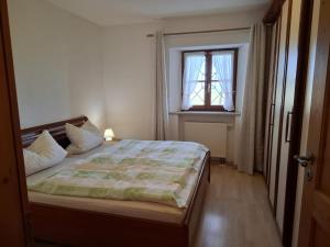a bedroom with a bed and a window at Beim Grafen in Frasdorf
