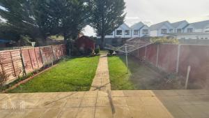 a backyard with a fence and a grass yard at The Fairway Garden in South Ruislip Station