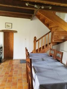 a dining room with a table and a wooden staircase at La maison de Francine in Plouézec
