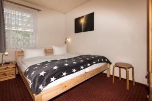 a bedroom with a bed with a black and white blanket at Ferienhaus Jupiter im Sternenpark in Lochow