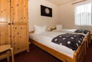 a bedroom with two beds and a wooden cabinet at Ferienhaus Jupiter im Sternenpark in Lochow