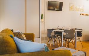 a living room with a couch and a table with chairs at Le Flocon Doré in Cauterets