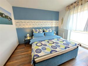 a bedroom with a blue and white bed with blue walls at Komfortferienwohnung Leuchtturm in Sassnitz