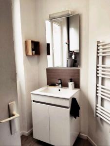 a bathroom with a white sink and a mirror at VILLA 240 m2, 16 Max, Parking, cour, salle de jeux in Épernay +70 photos