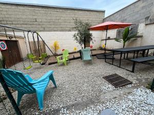 a playground with a swing and a table and an umbrella at VILLA 240 m2, 16 Max, Parking, cour, salle de jeux in Épernay