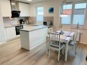 una cucina con tavolo e sedie in una cucina di Gezeitenfewo a Büsum Altre 17 foto