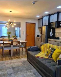 a living room and kitchen with a couch and a table at Loft aconchegante próximo ao Capivari in Campos do Jordão