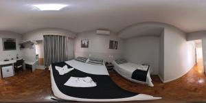 a room with two beds and a sink in it at Botucatu Hotel in Botucatu