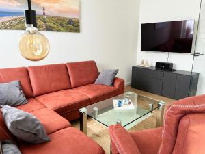 a living room with a couch and a tv at Haus Leni in Butjadingen