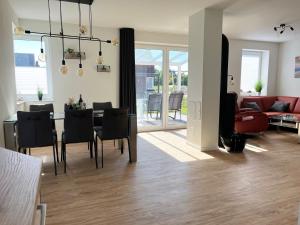 a living room and dining room with a table and chairs at Haus Leni in Butjadingen