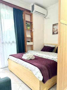 a bedroom with a bed with a purple blanket at Studio Astir in Tirane
