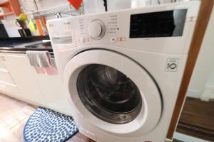 a white washing machine sitting in a kitchen at Just4u Guesthouse in Seoul