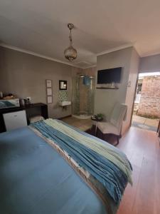 Un dormitorio con una cama con una manta azul encima. en Honeyball Guest rooms, en Mokopane