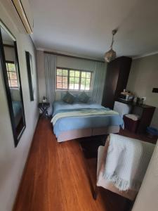 Un dormitorio con una cama y suelo de madera. en Honeyball Guest rooms, en Mokopane