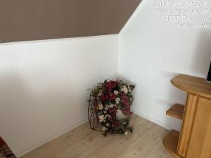 a bouquet of flowers sitting in a corner of a room at Wohnung im 2 Familienhaus in Dortmund