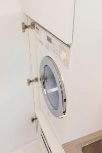 a washing machine in a white kitchen with a sink at luxuriöse Ferienwohnung in Mittenwald für Genießer in Mittenwald +5 photos