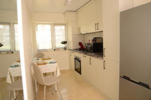 eine Küche mit weißen Schränken und einem Tisch mit Stühlen in der Unterkunft Central Premium Apartment in Iaşi + 19 Fotos