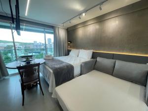 a hotel room with a bed and a couch and a table at RN Studio Premium Max Rev in Maceió +13 photos