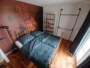 a bedroom with a bed and a wall at Rösslerhof Ferienwohnung Nachtweide in Schlier-Unterankenreute