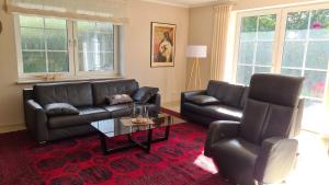 a living room with two leather couches and a coffee table at Ferienhaus Brombeerhof in Munkbrarup