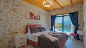 a bedroom with a bed and a stone wall at Villa TEPE in Arsaköy +68 photos