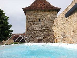 a water fountain in front of a stone building at La Maison Haute in Nailhac