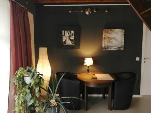 a room with a table and chairs and a lamp at KaalemHof Angelsen in Birresborn