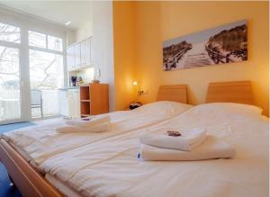 ein großes weißes Bett mit Handtüchern darüber in der Unterkunft Studio Ostseewind Residenz Seeblick in Ostseebad Sellin