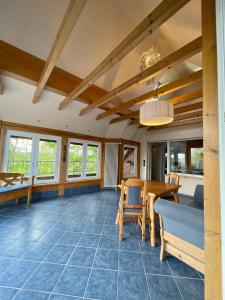 ein Wohnzimmer mit Tisch und Stühlen und Fenstern in der Unterkunft FeWo Eich im Emsland in Lingen