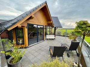 ein Haus mit einer Terrasse mit Stühlen und Tischen in der Unterkunft FeWo Eich im Emsland in Lingen