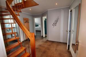 een hal met een trap in een huis bij Villa Aquila Luxus-Maisonette Ferienträume Dachterrasse in Göhren-Lebbin