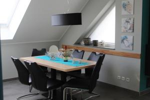 a dining room with a table and chairs at Villa Aquila Luxus-Maisonette Ferienträume Dachterrasse in Göhren-Lebbin