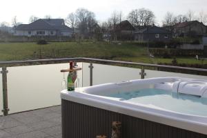 a jacuzzi tub with a bottle of wine in it at Villa Aquila Luxus-Maisonette Ferienträume Dachterrasse in Göhren-Lebbin +15 photos