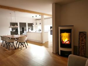 a living room with a table and a fireplace at Chalethaus-Chiemsee - Luxus 268 qm Ferienhaus am Chiemsee - Neubau in Prien am Chiemsee