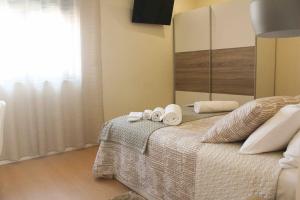 a bedroom with a bed with two towels and a mirror at Castro's guesthouse in Viana do Castelo +18 photos