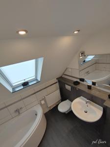 a bathroom with a toilet and a tub and a sink at Modernes Ruhrgebietsdomizil in Hattingen +1 photo