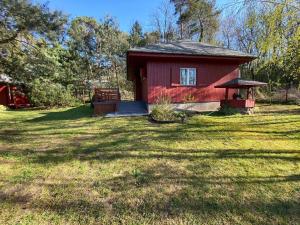 a red house in the middle of a yard at Boszkowski Azyl in Boszkowo-Letnisko +10 photos