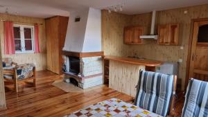 a kitchen with a fireplace and a table and chairs at Boszkowski Azyl in Boszkowo-Letnisko